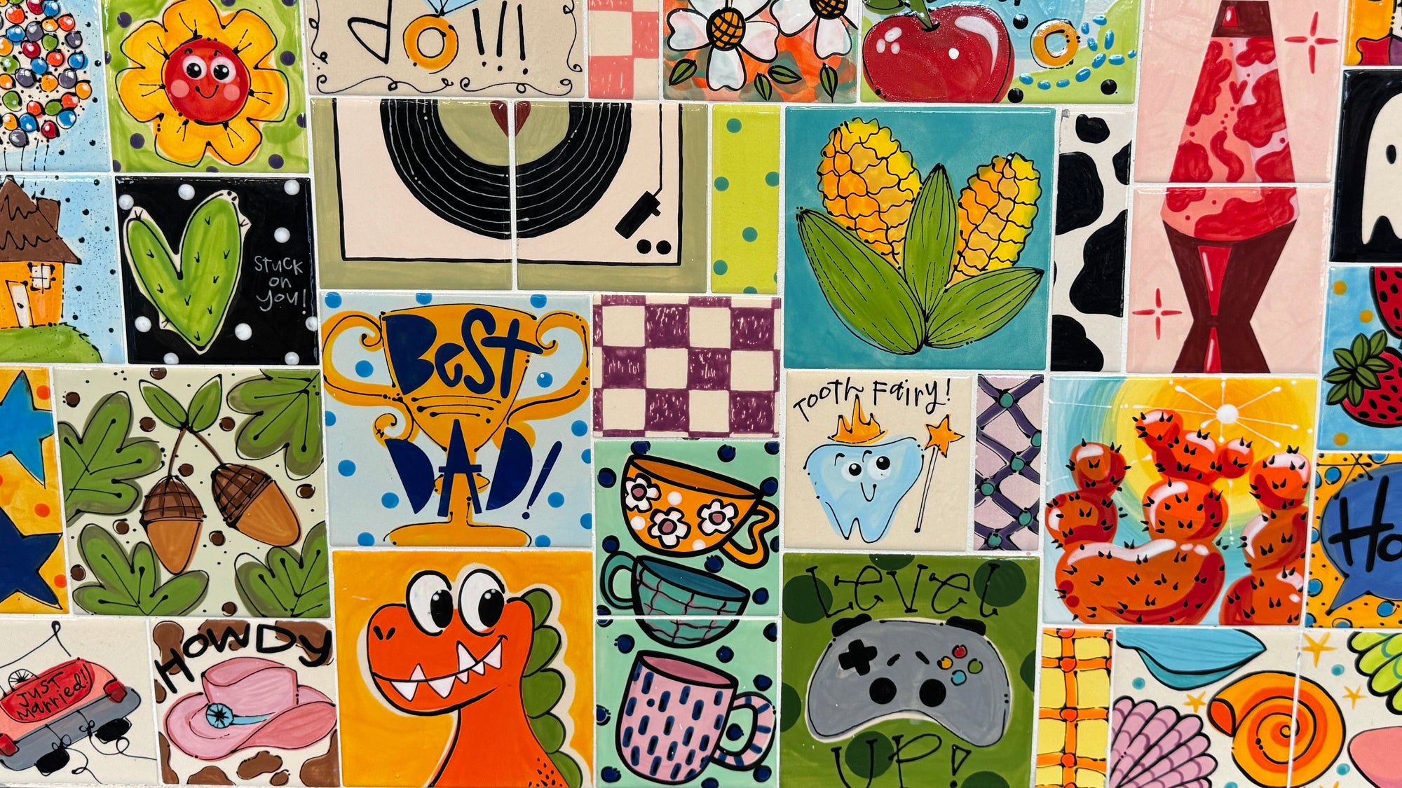 Collection of colorful ceramic tiles with various designs on a wall.