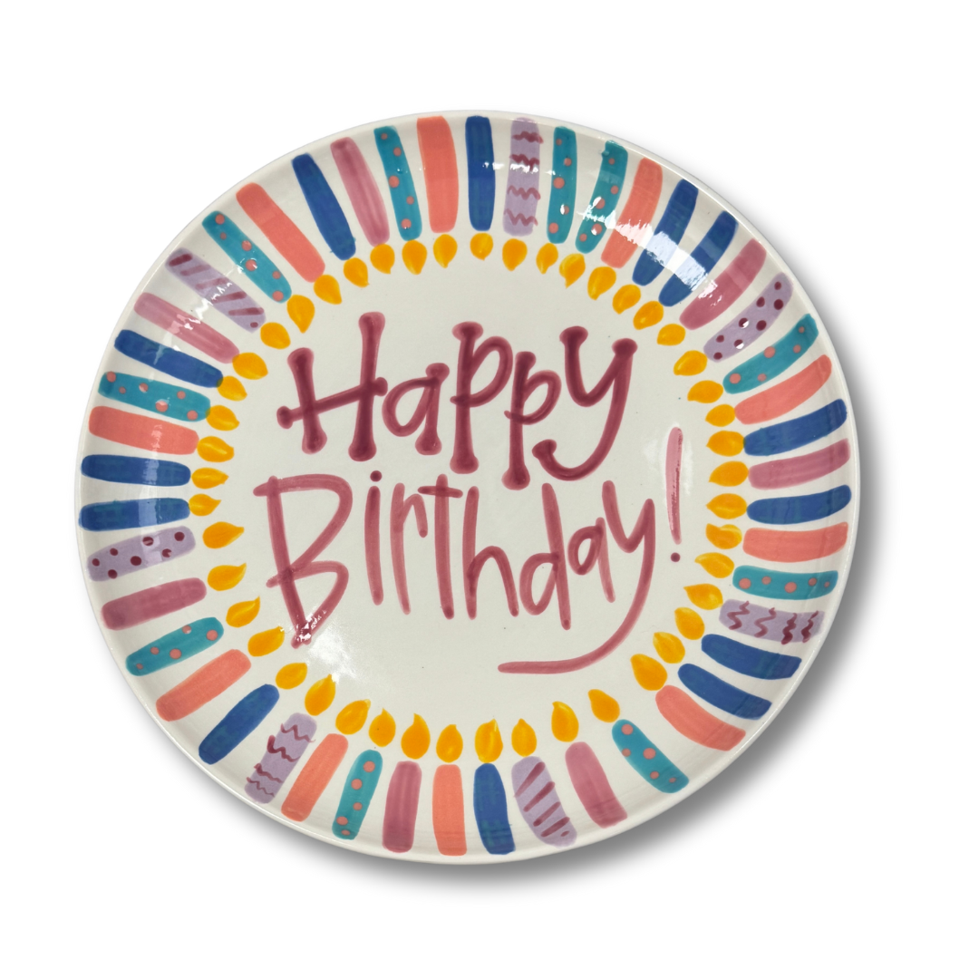Colorful candles on plate with 'Happy Birthday!' text on a white background