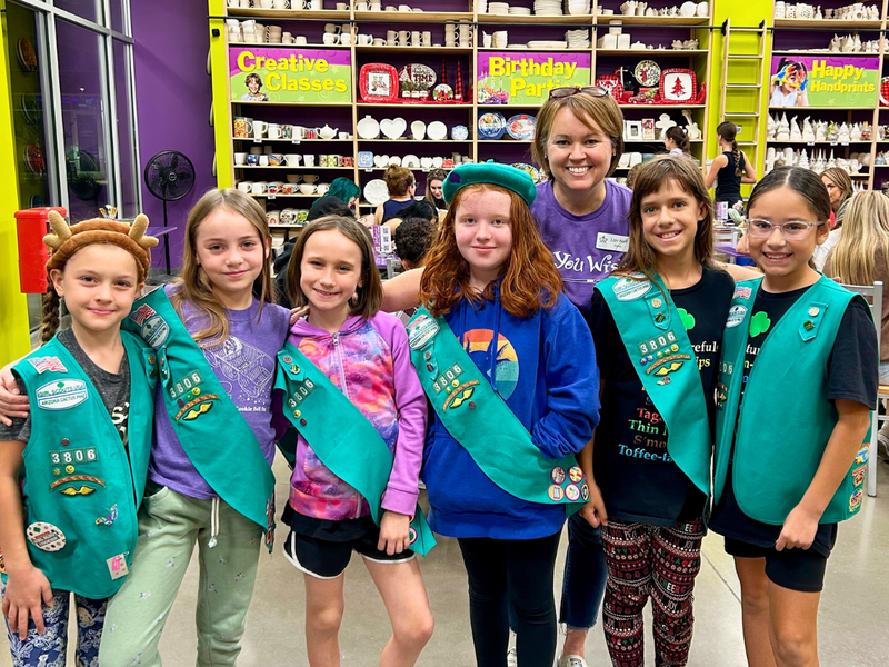Group of Girl Scouts posing for a photo in a store.
