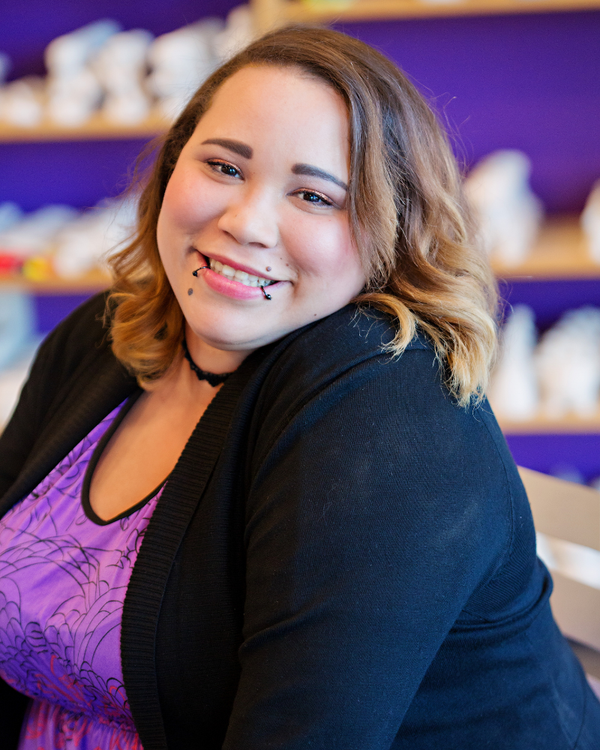 Woman with brown hair and a purple top in a store setting