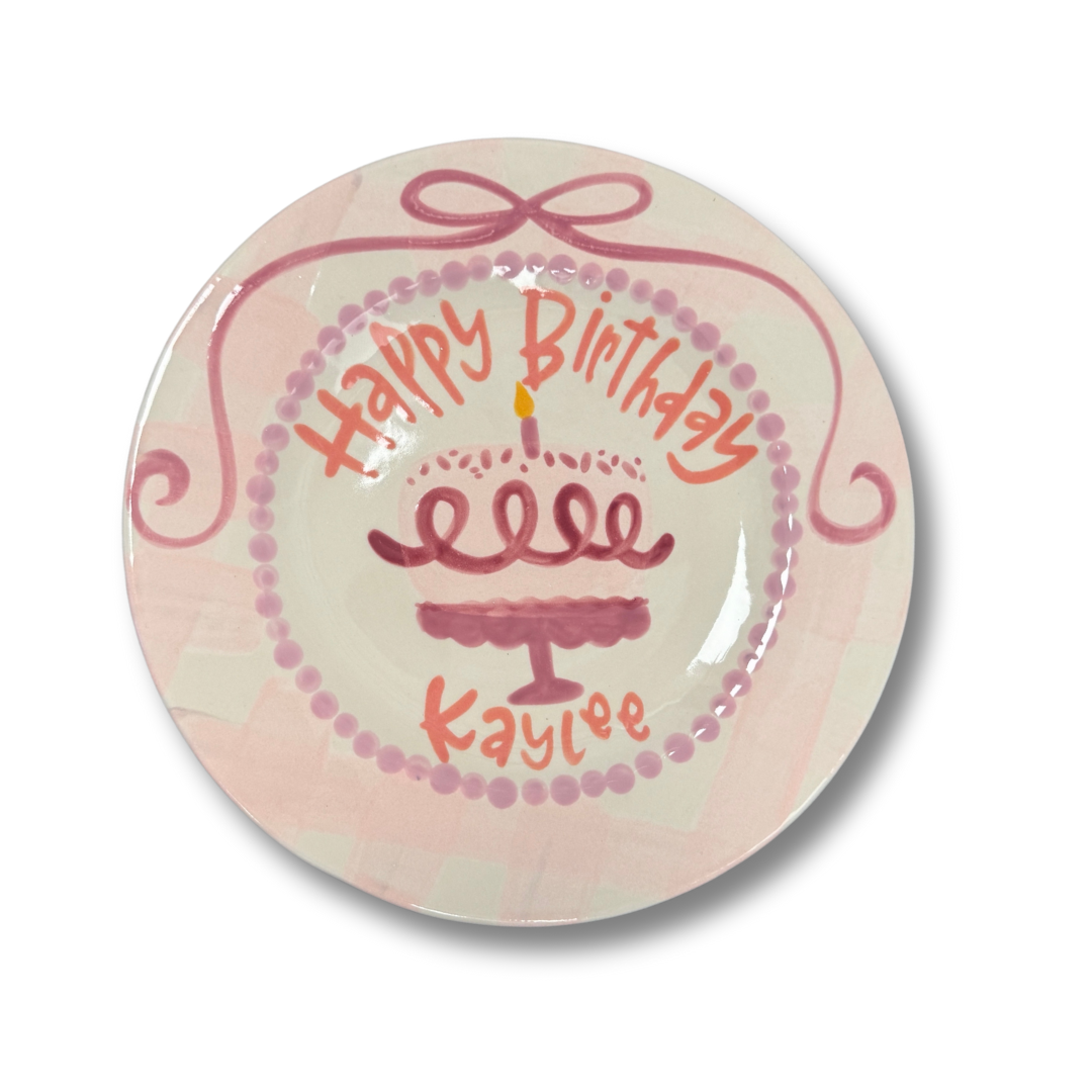 Round ceramic plate with 'Happy Birthday Kaylee' text and cake illustration on a white background