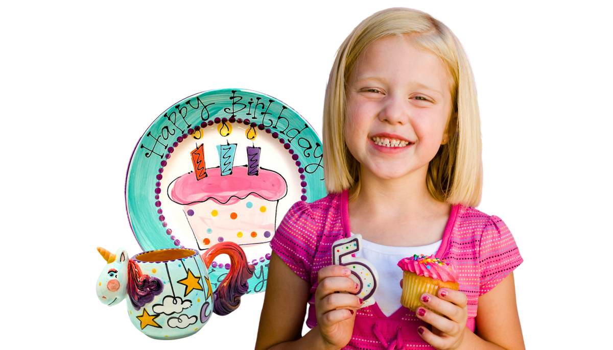 Young girl holding a birthday-themed plate and cupcake with a white background